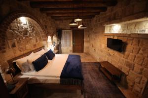 a bedroom with a bed in a stone wall at Ürgüp Cave Suites in Ürgüp
