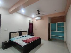 a bedroom with a bed and a ceiling fan at JK Royal Palace And Lodge in Allahābād