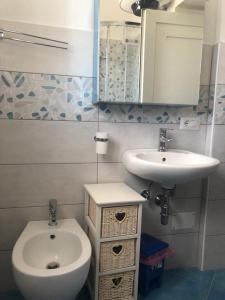 ein Badezimmer mit einem Waschbecken, einem WC und einem Spiegel in der Unterkunft Agenzia Isotur GINESTRA in Ponza