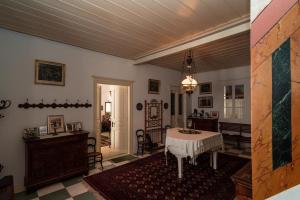 ein Wohnzimmer mit einem Tisch und einem Esszimmer in der Unterkunft Rafalias Mansion in Hydra