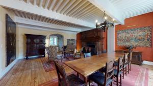 comedor con mesa de madera y sillas en Château du Chambon en Cerzat