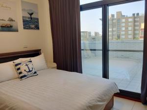 Un dormitorio con una cama y una ventana grande. en Pier 10, en Magong