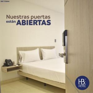 Hotel Blu Cúcuta في كوكوتا: سرير مع وسائد بيضاء في الغرفة