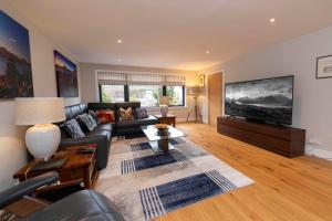 a living room with a couch and a flat screen tv at No. 7 Glamaig Place in Portree