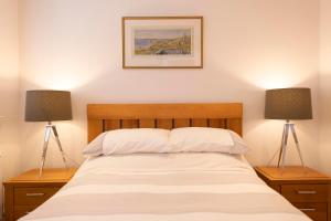 a bedroom with a bed with two lamps at No. 7 Glamaig Place in Portree
