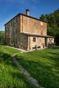 un gran edificio de ladrillo con un campo de hierba delante de él en Cà Colmello - Country House, en Gesso