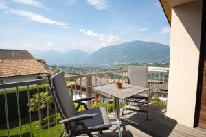 a balcony with a table and chairs and mountains at Apartment Prairerhof in Schenna