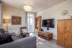 a living room with a couch and a tv at Perfect Location 2 Bed South Kensington Knightsbridge Chelsea with AC in London
