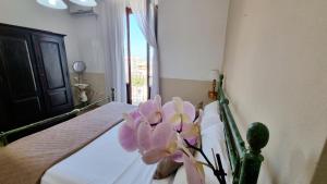 a room with a bed with purple flowers on it at Artemisia in Tropea