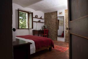 1 dormitorio con cama, mesa y ventana en Cà Colmello - Country House, en Gesso