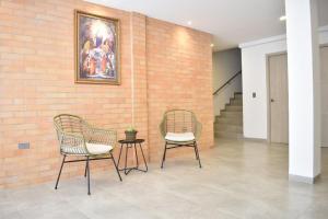 two chairs and a table next to a brick wall at Hotel Blu Cúcuta in Cúcuta