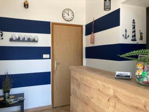 einen Flur mit blau und weiß gestreiften Wänden und einer Tür in der Unterkunft Apartments Ivančić in Novi Vinodolski