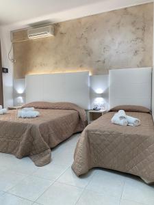 a bedroom with two beds with towels on them at Hotel Bahia in Caorle