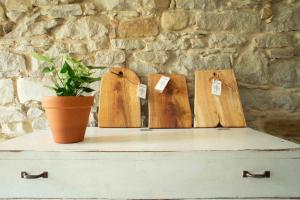 tres señales de madera en un pecho con una maceta en Cà Colmello - Country House, en Gesso