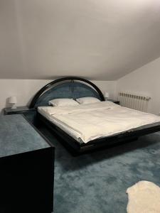 a bedroom with a large bed with white sheets at BSG Villa - Sinaia in Sinaia