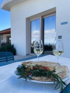 un piatto di cibo e due bicchieri di vino su un tavolo di Hotel Pranos Turismo Rurale Cala Gonone a Cala Gonone