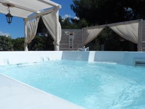 a swimming pool with an umbrella at B&B Santa Venardia in Gallipoli