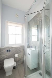 a bathroom with a shower and a toilet and a sink at 4 Crespigny House - Aldeburgh Coastal Cottages in Aldeburgh