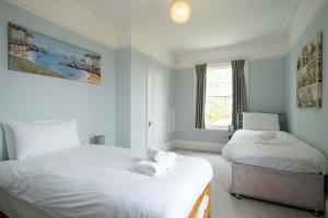 a bedroom with two beds and a window at 4 Crespigny House - Aldeburgh Coastal Cottages in Aldeburgh