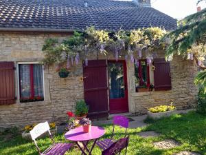 a table and chairs in front of a house at Aux Glycines in Marcilly-Ogny