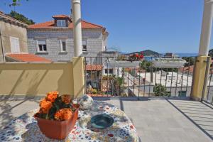 a table with a vase of flowers on a balcony at Guesthouse Manda in Dubrovnik
