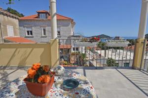 una mesa con un jarrón de flores en el balcón en Guesthouse Manda, en Dubrovnik