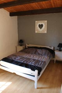 ein Bett in einem Schlafzimmer mit zwei Nachttischen und zwei Tischen in der Unterkunft Villa Frédérick (app. 5 personnes) in Bagnols-en-Forêt