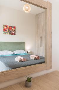 "Thea" Valis Apartments في Melissátika: غرفة نوم مع سرير مع مرآة كبيرة