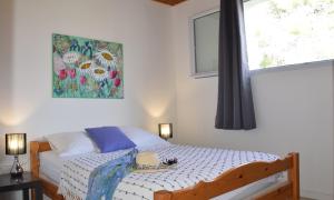 sypialnia z łóżkiem z obrazem na ścianie w obiekcie Locations "ChezChristine" à Aléria w mieście Aléria