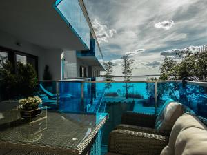 a house with a glass balcony with a view of the ocean at Aquarius Residence apartament 203 in Boszkowo