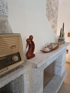 una chimenea con TV y estatuillas. en Villa Lina Salamina en Ambelákia