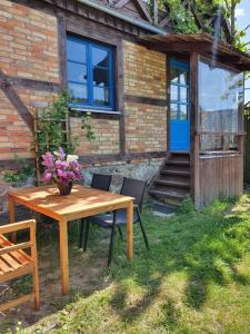 a wooden table and chairs in front of a house at BlaukehlchenBleibe in Groß Nemerow