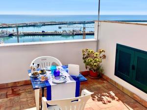 a table and chairs on a balcony with a view of the ocean at La casa del pescatore in Sciacca