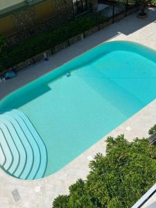 a large blue swimming pool with a chair in it at Sorrento City Apartment in Sorrento