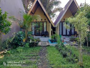 una casa con un jardín delante de ella en The Pondok, en Kuta Lombok