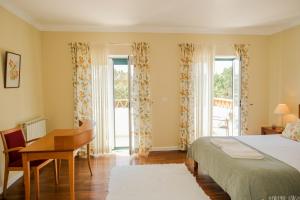 1 dormitorio con 1 cama, escritorio y 2 ventanas en São Lourenço Villa - Ericeira en Encarnação