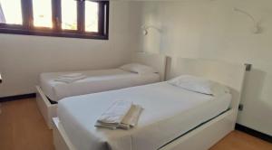 two white beds in a room with a window at Misericórdia Garden Homes in Vila do Conde