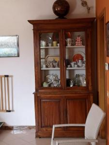 a wooden hutch in a living room with a chair at Villa Vecchio Ulivo in Sarconi