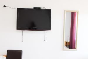 a flat screen tv hanging on a white wall at Charming studio Maša in Palić