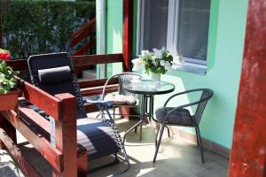 a patio with chairs and a table with a vase of flowers at Charming studio Maša in Palić