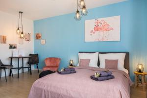 um quarto com uma cama rosa com duas toalhas em FREE LIVING - Tropical Design Apartments, Zentral, Parkplatz, Küche, Wlan em Wolfsburg