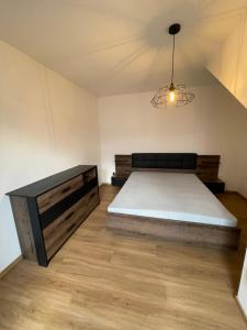 Un dormitorio con una cama grande y una lámpara de araña. en Apartmán Pálavská Brána en Brod nad Dyjí