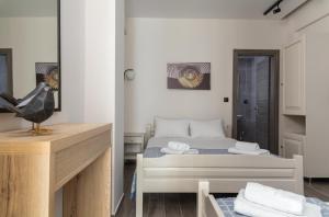 a small bedroom with a bed and a desk at Fani Guesthouse in Paralia Katerinis