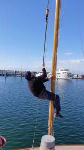 dos hombres parados en un poste en un barco en el agua en Haus Warnowblick Objekt 36737 en Rostock