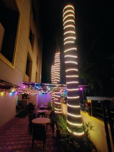 a lit up pole in a courtyard with tables and chairs at Procida Hostel by Zero Jhanjhat in Pune