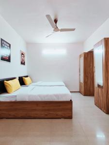 een slaapkamer met een bed en een plafondventilator bij Procida Hostel by Zero Jhanjhat in Pune