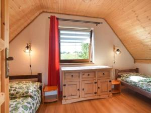 a attic bedroom with two beds and a window at Domki U Tadzia 603-425-844 in Polańczyk