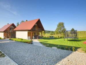 a house with a basketball hoop in the yard at Domki U Tadzia 603-425-844 in Polańczyk