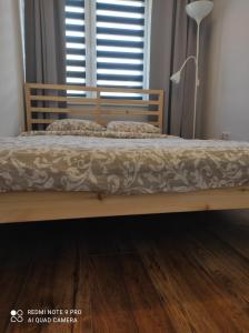 a wooden bed in a room with a window at Apartament Spokojny in Mielno