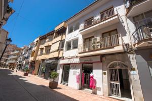 a building with a pink dress on a street at A&F Apartments in Nerja